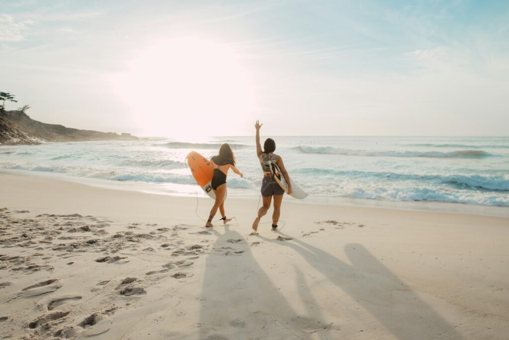 Two girls on the beach going surfing